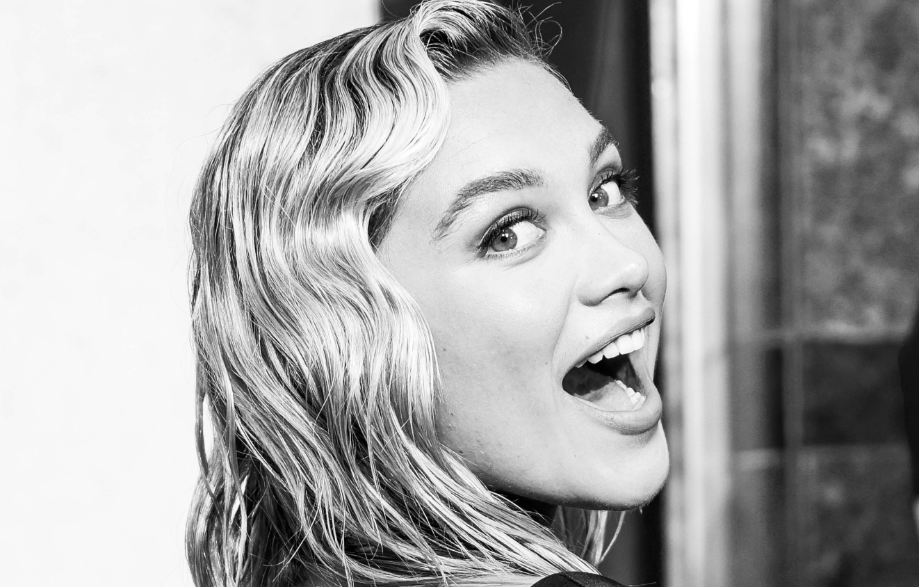 Portrait en noir et blanc de Florence Pugh souriant à la caméra à la première du film Black Widow.