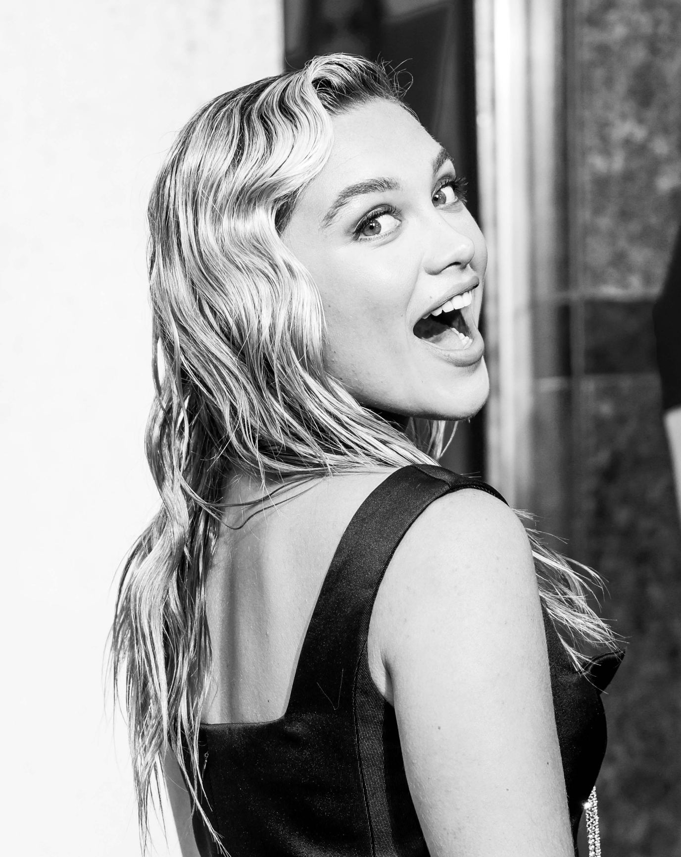 Portrait en noir et blanc de Florence Pugh souriant à la caméra à la première du film Black Widow.