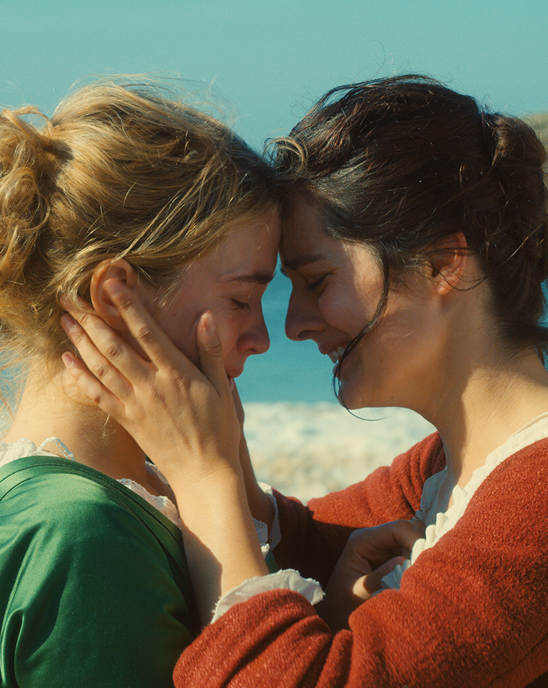 Adèle Haenel et Noémie Merlant s'enlacent face à la mer dans le film Portrait de la jeune fille en feu (2019).