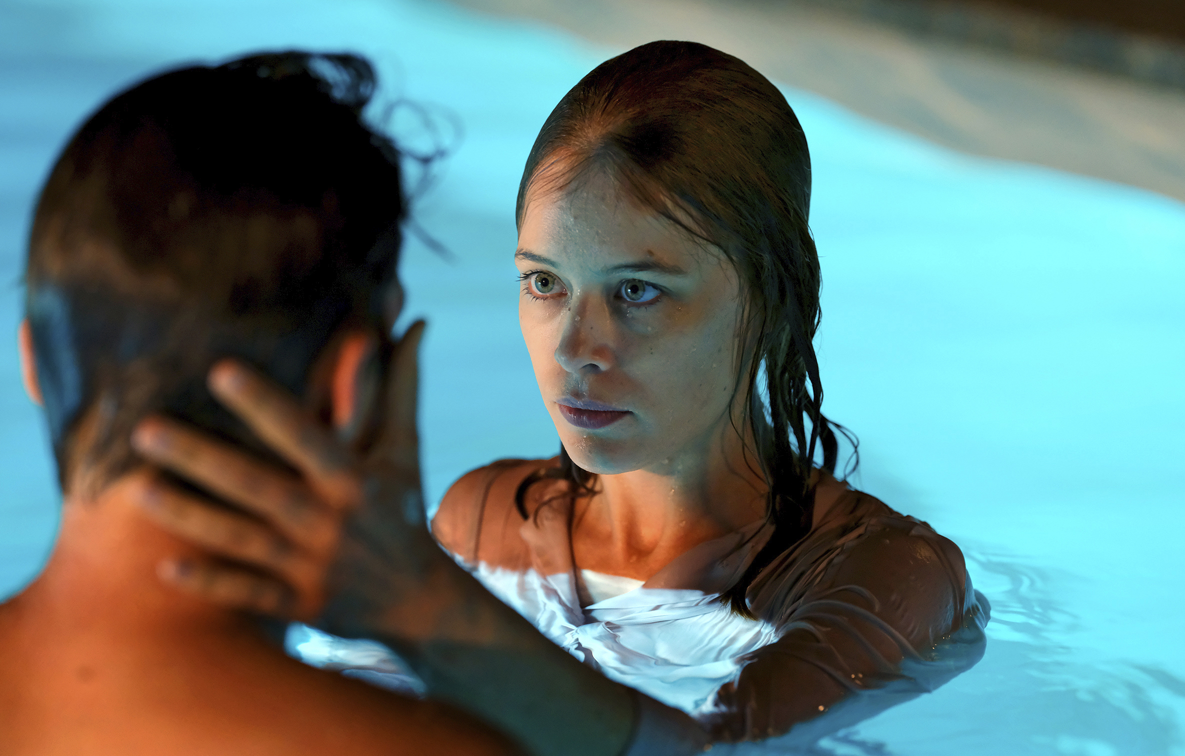 Paula Beer tient la tête d'un homme entre les mains dans une piscine dans le film Ondine (2020).